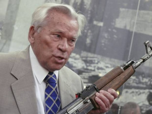 Elderly man holding a rifle, speaking.